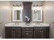 Bathroom with granite countertops, double sinks, and dark wood cabinets at 25605 69Th E Ave, Myakka City, FL 34251