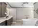 Bathroom with a free standing tub, double sinks, granite countertops, and decorative light fixtures at 25605 69Th E Ave, Myakka City, FL 34251