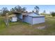 Exterior shot of detached garage with carport, featuring a metal roof and grey exterior siding at 25605 69Th E Ave, Myakka City, FL 34251