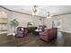 Cozy living room with hardwood floors, two ceiling fans, comfortable seating, and a television at 25605 69Th E Ave, Myakka City, FL 34251
