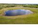 Aerial shot of the pond, well-maintained property, and manicured lawn at 25605 69Th E Ave, Myakka City, FL 34251