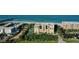 Aerial view of beachfront condominiums with a tennis court, pool, and mature landscaping at 2675 Gulf Of Mexico Dr # 301, Longboat Key, FL 34228
