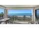 Balcony seating area with scenic ocean views, palm trees, and direct beach access at 2675 Gulf Of Mexico Dr # 301, Longboat Key, FL 34228