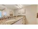 Bathroom featuring double sinks with granite countertops, a large mirror, and decorative wall accents at 2675 Gulf Of Mexico Dr # 301, Longboat Key, FL 34228