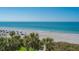 Beautiful view of the beach featuring lounge chairs, palm trees and clear turquoise waters at 2675 Gulf Of Mexico Dr # 301, Longboat Key, FL 34228
