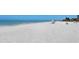 Wide beach with calm water and people enjoying the sun and sand at 2675 Gulf Of Mexico Dr # 301, Longboat Key, FL 34228