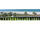 Beautiful beach view with palm trees and white sand, seen from a balcony with black railings at 2675 Gulf Of Mexico Dr # 301, Longboat Key, FL 34228