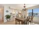 Dining room with chandelier, wooden table, and bar seating near kitchen, with a plant in the corner at 2675 Gulf Of Mexico Dr # 301, Longboat Key, FL 34228