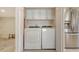 Well-equipped laundry room featuring a stacked washer and dryer, ample cabinet space, and stainless steel fridge at 2675 Gulf Of Mexico Dr # 301, Longboat Key, FL 34228