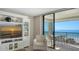 Cozy living room area with TV and ocean view from a large sliding glass door leading to balcony at 2675 Gulf Of Mexico Dr # 301, Longboat Key, FL 34228