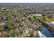 A sunny aerial view of a residential neighborhood with mature trees and lakefront properties at 28 Tall Trees Ct, Sarasota, FL 34232