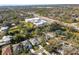 Stunning aerial view featuring lush landscaping and a large commercial building near residential homes at 28 Tall Trees Ct, Sarasota, FL 34232