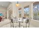 Breakfast nook with glass table offers views of the screened-in porch and a view of the open-concept living space at 28 Tall Trees Ct, Sarasota, FL 34232