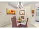 Charming dining room with glass table, seating for four, and decorative floral artwork at 28 Tall Trees Ct, Sarasota, FL 34232