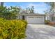 Inviting home with a spacious driveway, a two-car garage, and attractive landscaping at 28 Tall Trees Ct, Sarasota, FL 34232