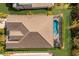 Aerial view of a home with a screened-in pool area, landscaping, and a large roof at 3605 Wild Blossom Pl, Parrish, FL 34219