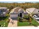 Aerial view of a beautifully landscaped home featuring a manicured lawn and brick driveway at 3605 Wild Blossom Pl, Parrish, FL 34219