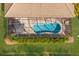 Aerial view of a screened-in pool area with lounge furniture, landscaping, and a clean pool at 3605 Wild Blossom Pl, Parrish, FL 34219