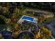 Aerial view of community pool, playground, and clubhouse amidst lush landscaping and mature trees at 3605 Wild Blossom Pl, Parrish, FL 34219