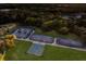 Aerial view of community tennis and pickleball courts surrounded by lush landscaping and mature trees at 3605 Wild Blossom Pl, Parrish, FL 34219