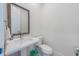 Comfortable half bathroom with white vanity and a toilet at 418 Magnolia Ave, Anna Maria, FL 34216