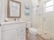 Clean bathroom with a glass enclosed shower, toilet, and white vanity at 418 Magnolia Ave, Anna Maria, FL 34216