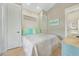 Cozy bedroom with white walls and white comforter, with light blue accents and beachy wall art at 418 Magnolia Ave, Anna Maria, FL 34216