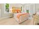 Bright bedroom with tropical-themed decor, wood-look tile flooring, and plenty of natural light at 418 Magnolia Ave, Anna Maria, FL 34216