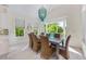 Light-filled dining room boasts floor-to-ceiling windows, light tile floors, and a modern chandelier at 418 Magnolia Ave, Anna Maria, FL 34216