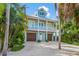 Charming two-story coastal home featuring a light blue exterior, white trim, and a welcoming front porch at 418 Magnolia Ave, Anna Maria, FL 34216