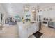 Open-concept kitchen with an island featuring white cabinets, stainless steel appliances, and seamless flow to the living area at 418 Magnolia Ave, Anna Maria, FL 34216