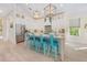 Modern kitchen with a large island, white cabinetry, stainless steel appliances, and stylish turquoise barstools at 418 Magnolia Ave, Anna Maria, FL 34216