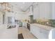 Well-appointed kitchen with white cabinetry, mosaic backsplash, modern appliances, and sleek countertops at 418 Magnolia Ave, Anna Maria, FL 34216