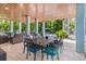 Elegant outdoor dining area under a covered patio, perfect for enjoying meals with a view of the lush backyard at 418 Magnolia Ave, Anna Maria, FL 34216