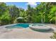 Inviting pool and spa combination nestled in a lush backyard, perfect for relaxation and entertaining at 418 Magnolia Ave, Anna Maria, FL 34216