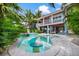 Stunning backyard pool and spa with lush tropical landscaping, complemented by the charming two-story home at 418 Magnolia Ave, Anna Maria, FL 34216