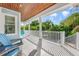 Inviting covered porch features wood ceiling, light tile floor, and views of the surrounding tropical landscape at 418 Magnolia Ave, Anna Maria, FL 34216