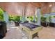 Exterior view of a covered recreational area featuring a pool table and lounge area at 418 Magnolia Ave, Anna Maria, FL 34216
