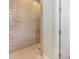 Elegant shower with unique tile, bright white walls, and seamless glass door at 418 Magnolia Ave, Anna Maria, FL 34216