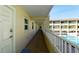 Exterior hallway with a balcony overlooking a pool and other condo buildings at 4200 Gulf Dr # 101, Holmes Beach, FL 34217