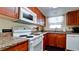 Well-lit kitchen featuring granite countertops and modern white appliances at 4200 Gulf Dr # 101, Holmes Beach, FL 34217