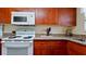 Charming kitchen featuring granite countertops, a white range, and updated appliances at 4200 Gulf Dr # 101, Holmes Beach, FL 34217