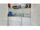 Efficient laundry room featuring washer, dryer, and storage shelving at 4200 Gulf Dr # 101, Holmes Beach, FL 34217
