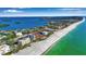 Stunning aerial view of waterfront property with a pristine white sand beach and clear turquoise water at 4234 Gulf Of Mexico Dr # H2, Longboat Key, FL 34228