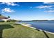 Scenic backyard with lush green lawn and waterfront access with kayaks, set against a tranquil bay at 4234 Gulf Of Mexico Dr # H2, Longboat Key, FL 34228