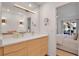 Bright bathroom featuring a double sink vanity with modern lighting and a glimpse into the adjacent bedroom at 4234 Gulf Of Mexico Dr # H2, Longboat Key, FL 34228