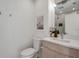 Modern bathroom features a toilet and a sink with a stylish mirror and wall art for added elegance at 4234 Gulf Of Mexico Dr # H2, Longboat Key, FL 34228
