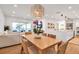 Open concept dining room featuring a light wood table, woven chairs, contemporary lighting, and views of the water at 4234 Gulf Of Mexico Dr # H2, Longboat Key, FL 34228