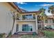 A view of the home and second-story balcony showing two chairs, and a partial water view at 4234 Gulf Of Mexico Dr # H2, Longboat Key, FL 34228