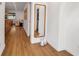 Bright hallway with hardwood floors, decorative mirror, and a glimpse into the living spaces at 4234 Gulf Of Mexico Dr # H2, Longboat Key, FL 34228